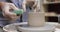 male hands making ceramic cup on pottery wheel