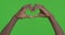 Male hands making heart symbol against chroma key background