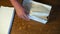 Male hands manipulate a cardboard box on a wooden table.view from above.