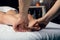 Male hands of a massage therapist does a woman foot massage