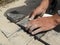 Male hands pave a sidewalk stone