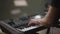 Male hands play synthesizer. Fingers press keys. Male musician, piano accompanist on black and white keyboards during