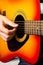 Male hands playing acoustic guitar, close up