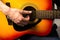 Male hands playing acoustic guitar, close up