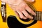 Male hands playing acoustic guitar, close up