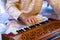 Male hands playing keys on harmonium