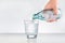 Male hands pouring bottled water into glass. Water glass with copy space.