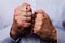 Male hands praying holding a beads rosary with Jesus Christ in the cross or Crucifix