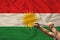 Male hands of a prisoner in iron chains against the background of the national flag of kurdistan, rojava, concept of political