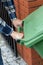 Male hands pushing a wheeled dumpster