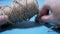 Male Hands Reel Up Jute Twine, Rope on Reel. Close-up, Blue Background. Flax