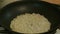 Male hands salted fried onions in a frying pan. Russian cuisine.