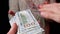 Male Hands Scatter Stack of 100 US Dollar Bills on Black Background. Money. 4K