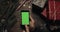 Male hands scrolling, tapping, zooming pages on the black smartphone with green screen. Chroma key. Top view. Vertical