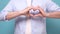 Male hands show heart gesture isolated on blue background