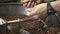 Male hands stirring coffee beans in grinder machine