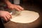 Male hands stretching the dough. Proces of making homemade croissants with butter