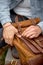 Male hands taking leather brown handmade Backpack on walk, close-up photo.