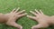 Male hands is touching artificial lawn grass.