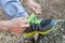 Male hands tying up shoelaces on a running sneaker, close up. Part of sportsman tying sneakers. Leg on a rock.