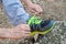 Male hands tying up shoelaces on a running sneaker, close up. Part of sportsman tying sneakers. Leg on a rock.