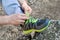 Male hands tying up shoelaces on a running sneaker, close up. Part of sportsman tying sneakers. Leg on a rock.