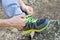 Male hands tying up shoelaces on a running sneaker, close up. Part of sportsman tying sneakers. Leg on a rock.