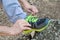 Male hands tying up shoelaces on a running sneaker, close up. Part of sportsman tying sneakers. Leg on a rock.