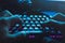 Male hands typing on the black illuminated keyboard with blue light