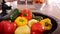 Male hands washing lots of bell peppers at the kitchen sink