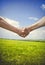 Male handshake on wheat field in summer time