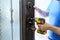 Male handyman carpenter at interior metal door lock installation