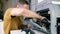 A male handyman inspects a printer before starting repairs at the service center.