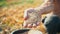 Male hard-working hand shows a full palm of grain. Grain in the hand of a farmer on the background of the earth