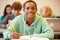 Male High School Student Studying At Desk In Classroom