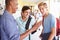 Male High School Students By Lockers Looking At Mobile Phone