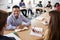 Male High School Tutor With Pupils Sitting At Table Teaching Maths Class