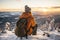 Male hiker admiring a scenic view from a snowy mountain top. Adventurous young man with a backpack. Hiking and trekking on a