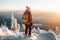 Male hiker admiring a scenic view from a snowy mountain top. Adventurous young man with a backpack. Hiking and trekking on a