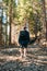 Male hiker with a backpack on his back walks on a mountain trail, rear view. Vertical