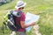 male hiker in hat with backpack thermos tourist mat and map