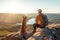 Male hiker and his pet dog admiring a scenic view from a mountain top. Adventurous young man with a backpack. Hiking and trekking