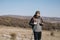 Male hiker holding poles and hiking radio