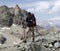 Male hiker on a rocky and dusty hiking trail in the French Alps