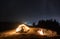 Male hiker sitting inside camp tent and playing guitar at night.