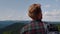 Male hiker standing on top of mountain. Redhead man looking summer landscape