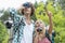 Male hiker using binoculars while girlfriend showing something in forest