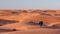 Male hiker is walking on sand dunes field