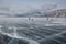 male hikers with backpacks walking on ice water surface during daytime,,russia, lake