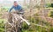 Male horticulturist working with wooden girders in garden